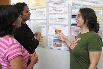 Student presenting a poster to other students