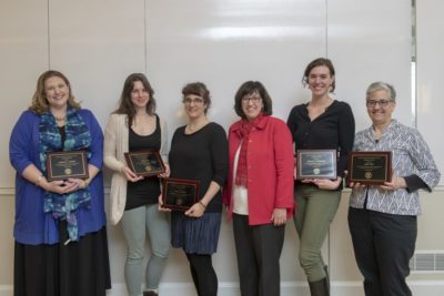 Image of six women, some holding plaques, listed left to right: Michelle Artibee, Tisha Bohr, Hale Tufan, Cornell President Martha E. Pollock, doctoral student Natalie Hofmeister, and Abby Cohn.