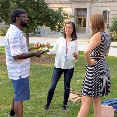 Alumni Dhyan, Lucy, and Lauren outside on the Ag Quad practicing elevator pitches