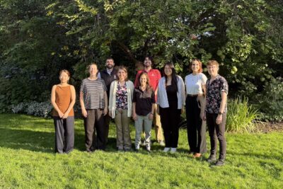 9 postdocs lined up outdoors in the evening